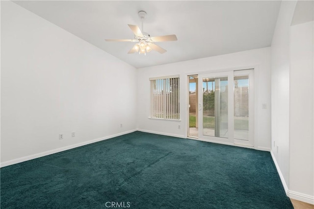 empty room featuring vaulted ceiling, baseboards, and dark carpet