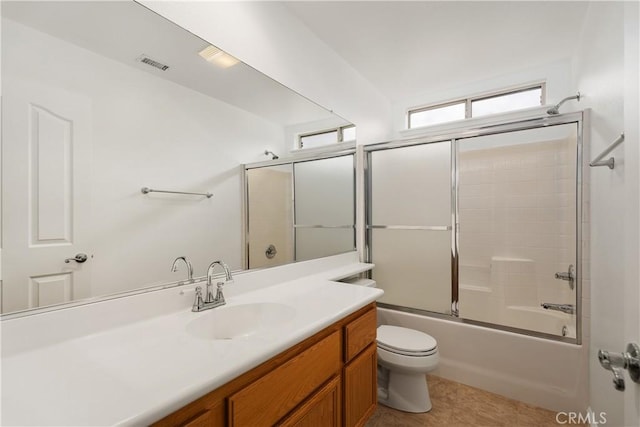 bathroom featuring visible vents, toilet, tile patterned flooring, bath / shower combo with glass door, and vanity