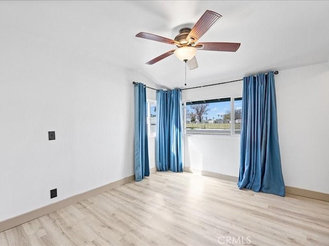 unfurnished room with ceiling fan, wood finished floors, lofted ceiling, and baseboards