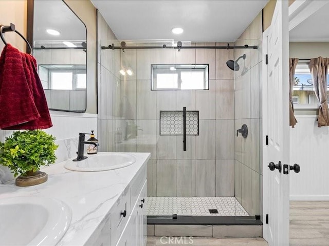 bathroom with a stall shower, a wealth of natural light, and a sink