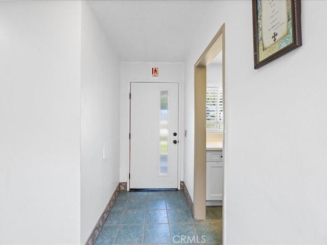 entryway with tile patterned flooring and baseboards