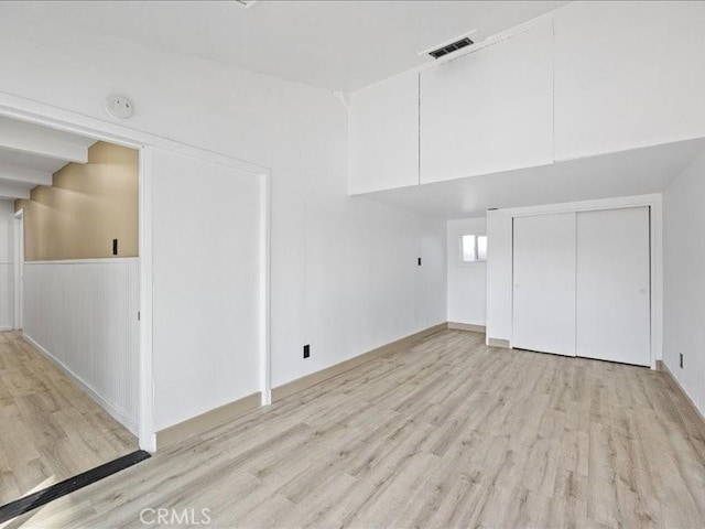 additional living space with a wainscoted wall, visible vents, and wood finished floors