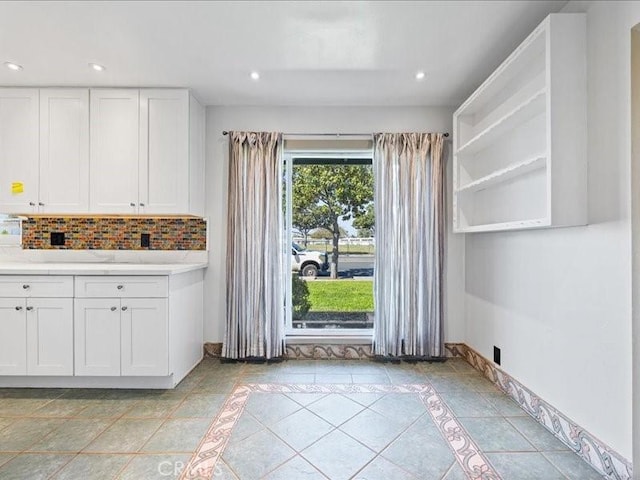kitchen with white cabinetry, decorative backsplash, light countertops, and recessed lighting
