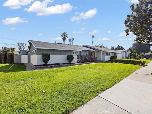 single story home featuring a front yard and fence