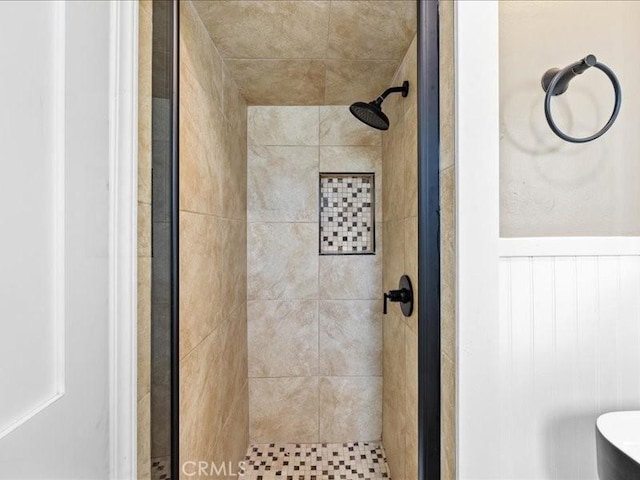 bathroom featuring a stall shower and wainscoting
