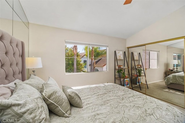 carpeted bedroom with a closet, vaulted ceiling, baseboards, and ceiling fan