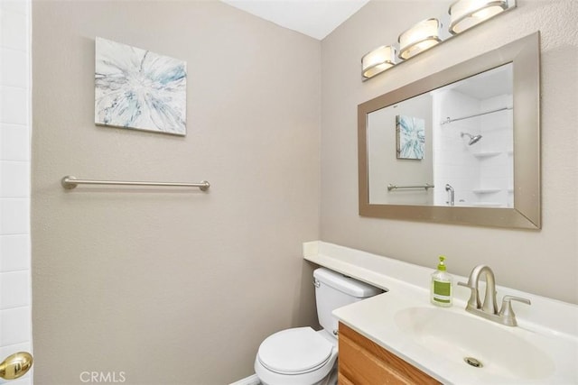 full bathroom featuring vanity, walk in shower, and toilet