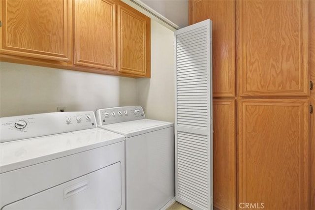 laundry area featuring independent washer and dryer and cabinet space