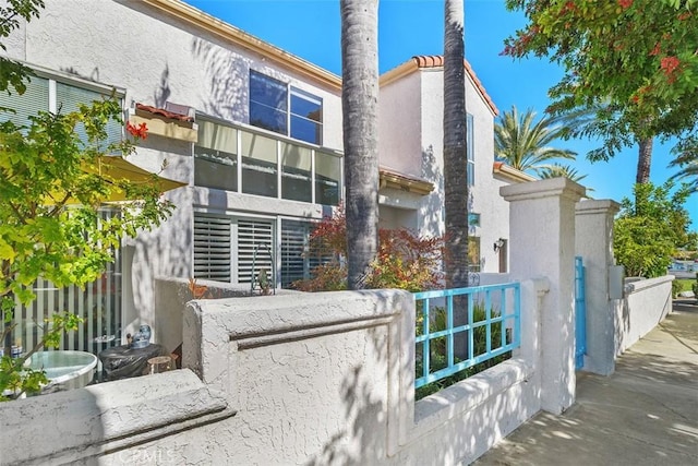 view of property exterior with fence and stucco siding