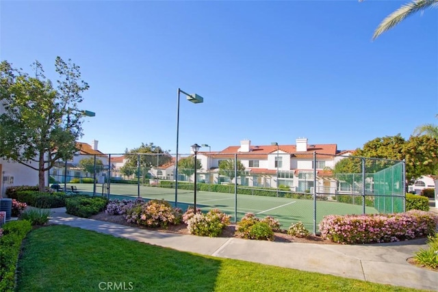 view of sport court with a yard, a residential view, and fence