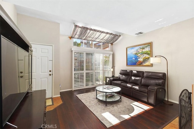 living area with visible vents, baseboards, and wood finished floors