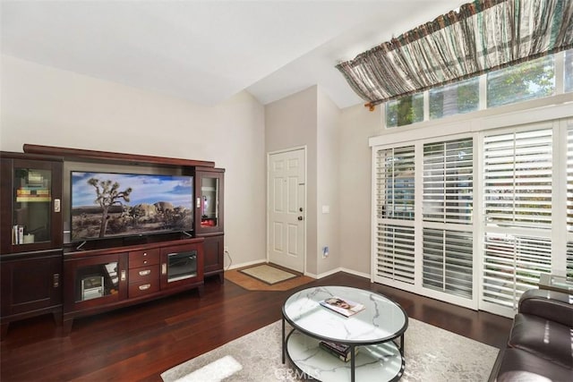 living room with lofted ceiling, baseboards, and wood finished floors