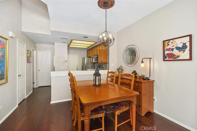 dining space with baseboards, visible vents, a chandelier, and wood finished floors