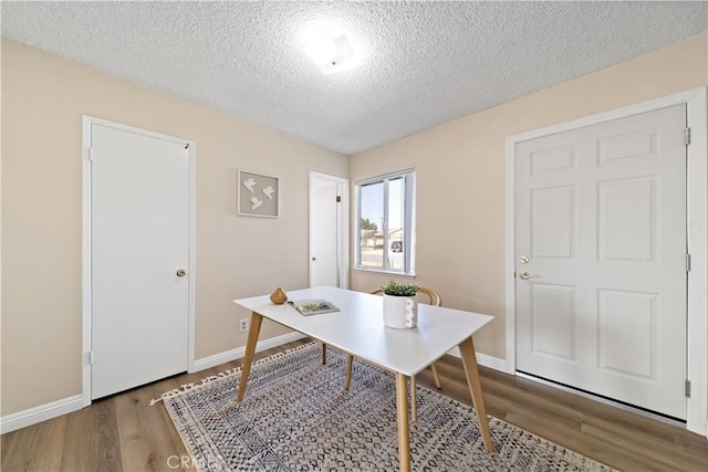 home office with a textured ceiling, wood finished floors, and baseboards