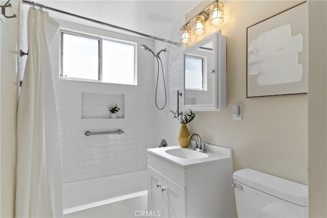 bathroom featuring toilet, shower / bath combo with shower curtain, and vanity