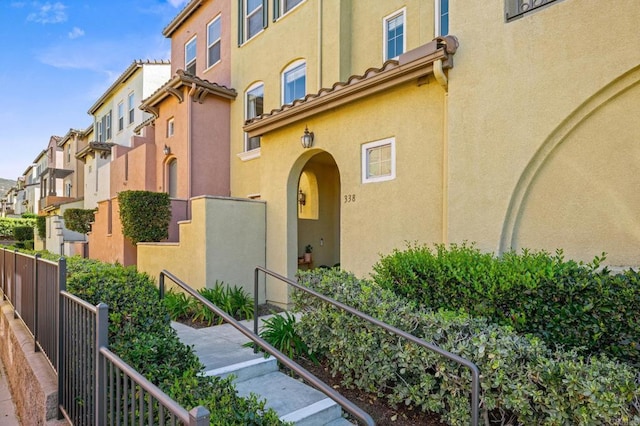 entrance to property with a residential view, a tiled roof, and stucco siding