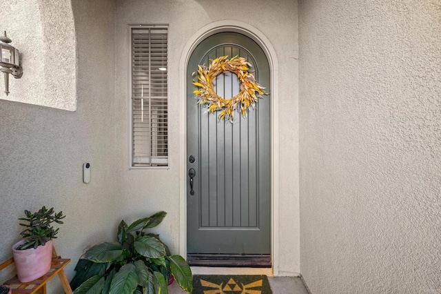 doorway to property featuring stucco siding