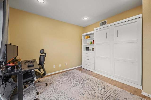 office space featuring light wood finished floors, visible vents, baseboards, and recessed lighting