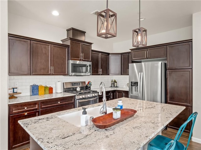 kitchen featuring stainless steel appliances, light stone countertops, dark brown cabinets, and tasteful backsplash