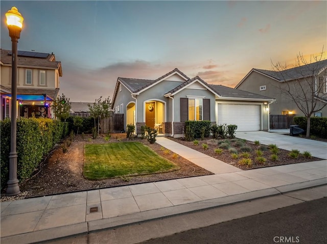 view of front of home with an attached garage, fence, a tile roof, concrete driveway, and stucco siding