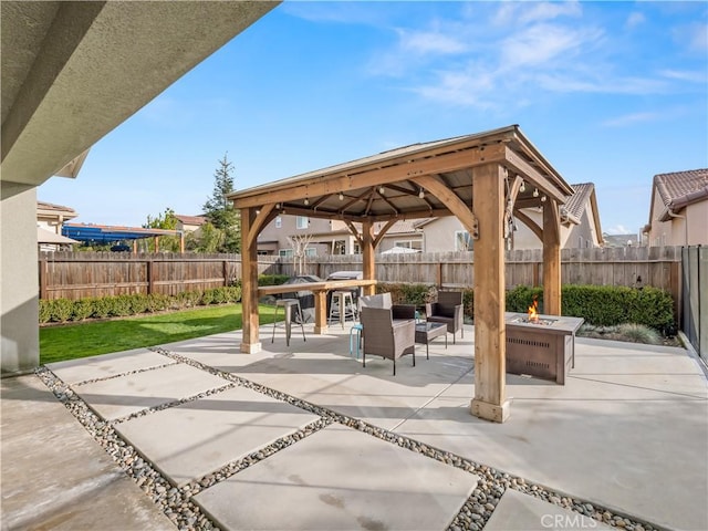 view of patio / terrace featuring an outdoor living space with a fire pit, a fenced backyard, and a gazebo