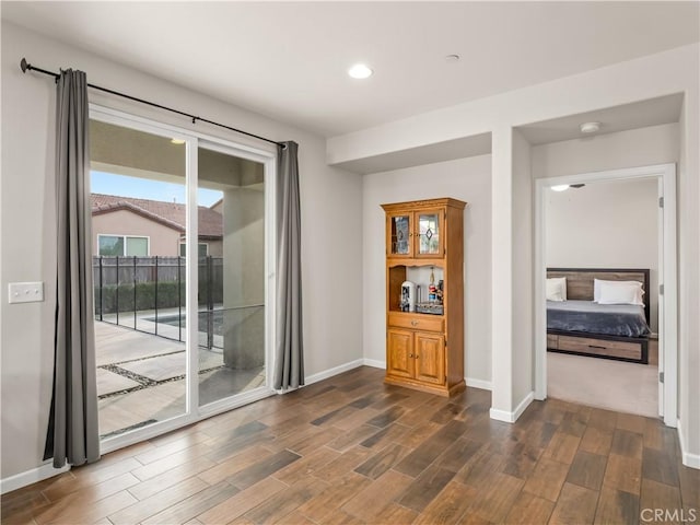 spare room featuring dark wood-type flooring, recessed lighting, and baseboards