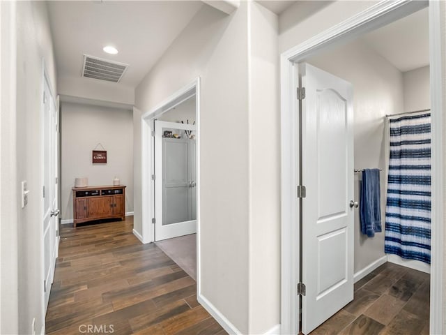 hallway featuring wood finish floors, visible vents, baseboards, and recessed lighting