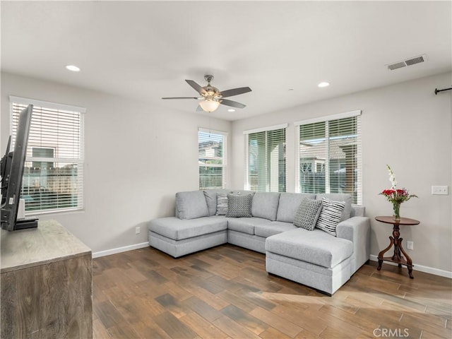 living area with baseboards, visible vents, wood finished floors, and recessed lighting