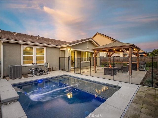 pool at dusk featuring central AC unit, a fire pit, a patio, fence, and a gazebo