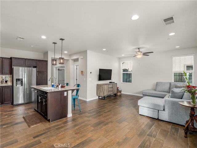 kitchen featuring open floor plan, stainless steel appliances, a sink, and visible vents