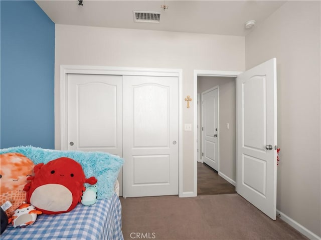 bedroom featuring carpet floors, baseboards, visible vents, and a closet