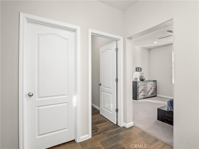 hallway with baseboards and wood finish floors