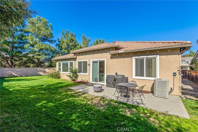 rear view of property with a patio, cooling unit, a fenced backyard, a yard, and stucco siding