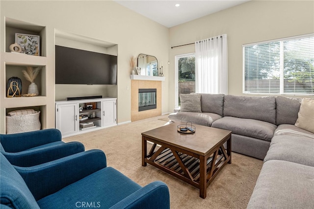 carpeted living area with a tiled fireplace, a wealth of natural light, and recessed lighting