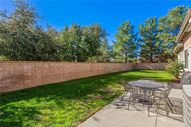 view of yard featuring a patio, outdoor dining space, and a fenced backyard