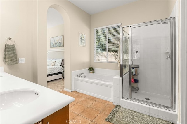 full bathroom featuring a garden tub, a shower stall, tile patterned flooring, and ensuite bathroom