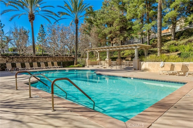 pool with a patio area and a pergola