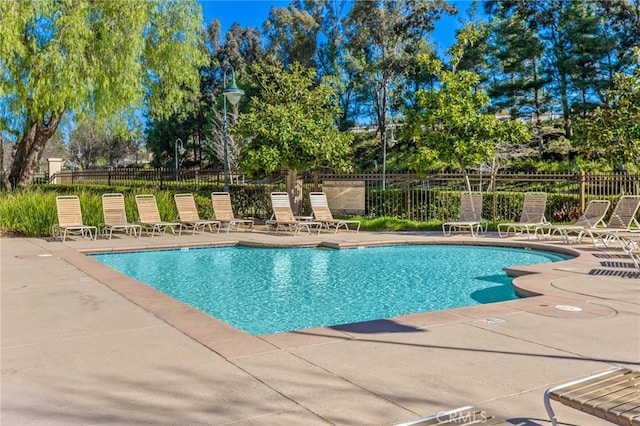 community pool featuring a patio area and fence