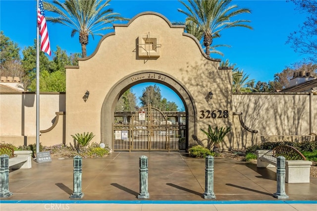 exterior space with fence, a gate, and stucco siding