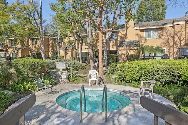 view of swimming pool with a hot tub