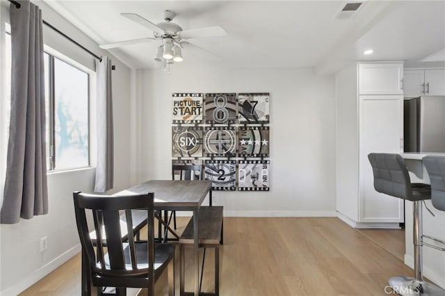 dining room with light wood-type flooring, plenty of natural light, visible vents, and baseboards