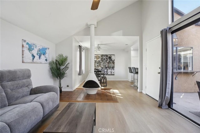 interior space featuring high vaulted ceiling, ceiling fan, baseboards, and wood finished floors