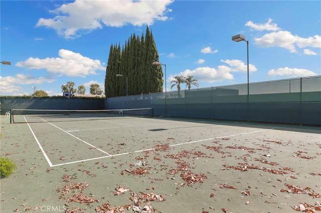 view of tennis court featuring fence