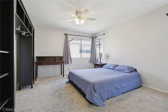 carpeted bedroom with ceiling fan and baseboards