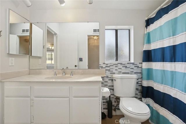 full bathroom featuring visible vents, toilet, tile walls, and vanity