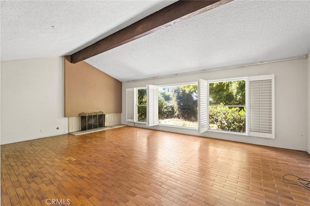 unfurnished living room with lofted ceiling with beams, a textured ceiling, and wood finished floors