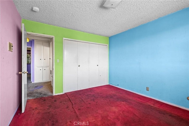 unfurnished bedroom featuring carpet, a closet, baseboards, and a textured ceiling