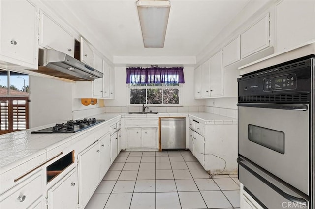 kitchen featuring appliances with stainless steel finishes, white cabinets, and under cabinet range hood