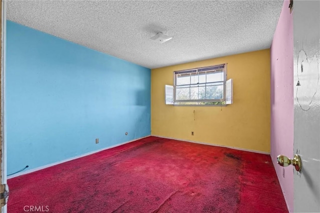 empty room with carpet and a textured ceiling