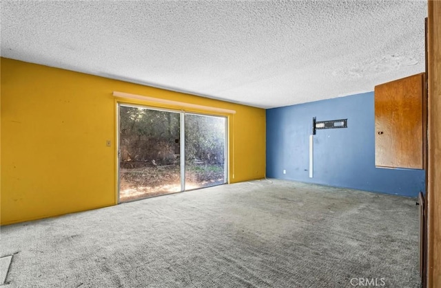 unfurnished room with a textured ceiling and carpet flooring